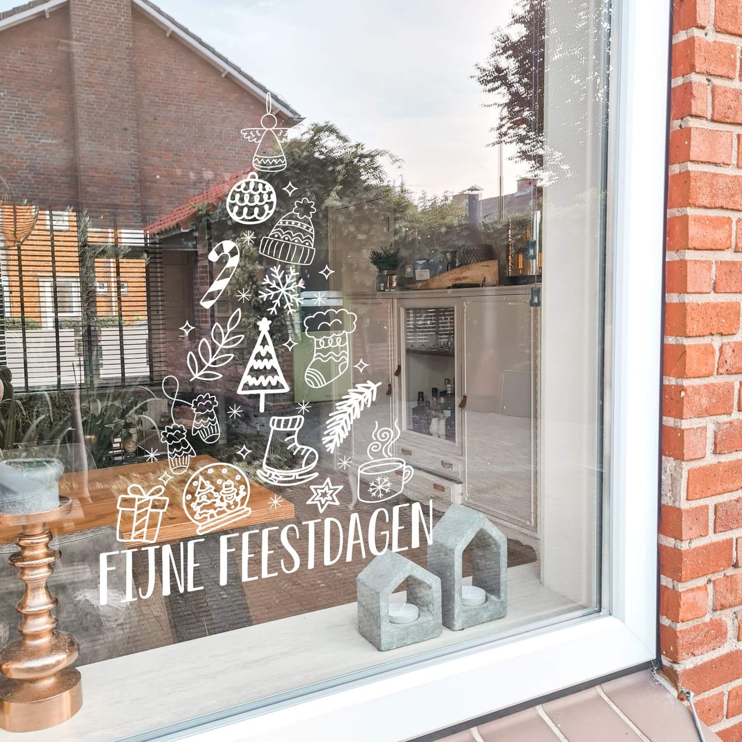 Raamsticker in vorm van een kerstboom met kleine winter tekeningetjes, onderaan fijne feestdagen