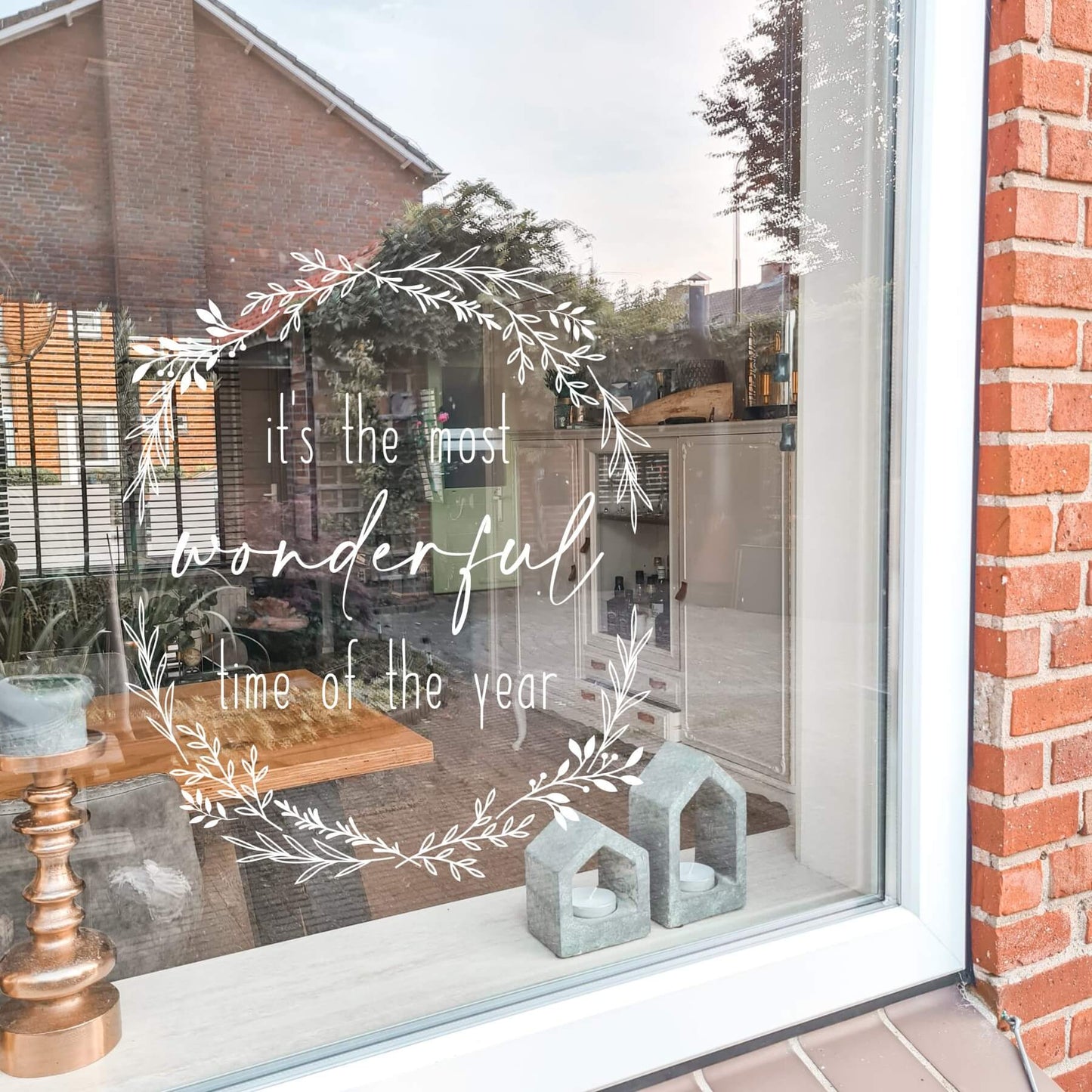 Raamsticker met ronde bladeren krans met de tekst it's the most wonderful time of the year