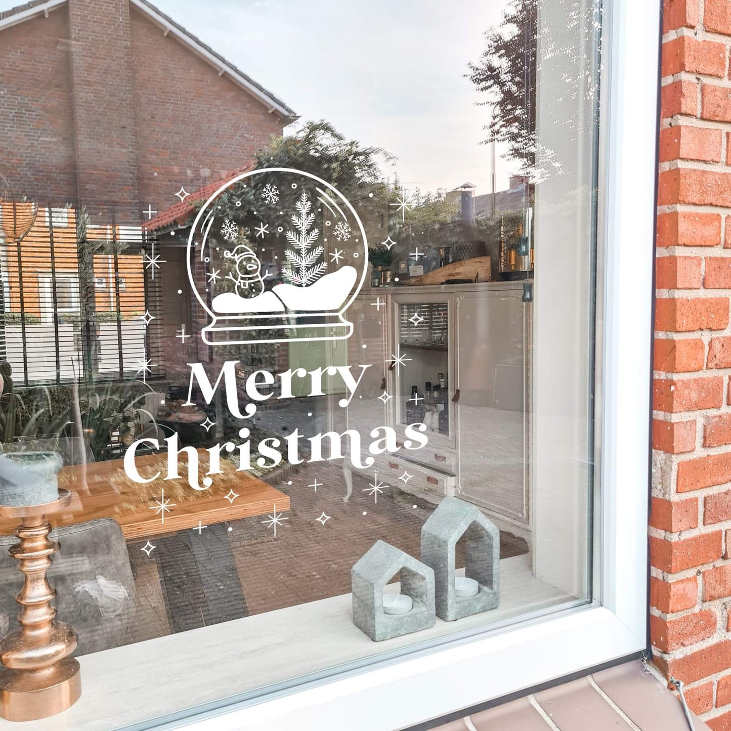 raamsticker met sneeuwbol en sterren met de tekst merry christmas